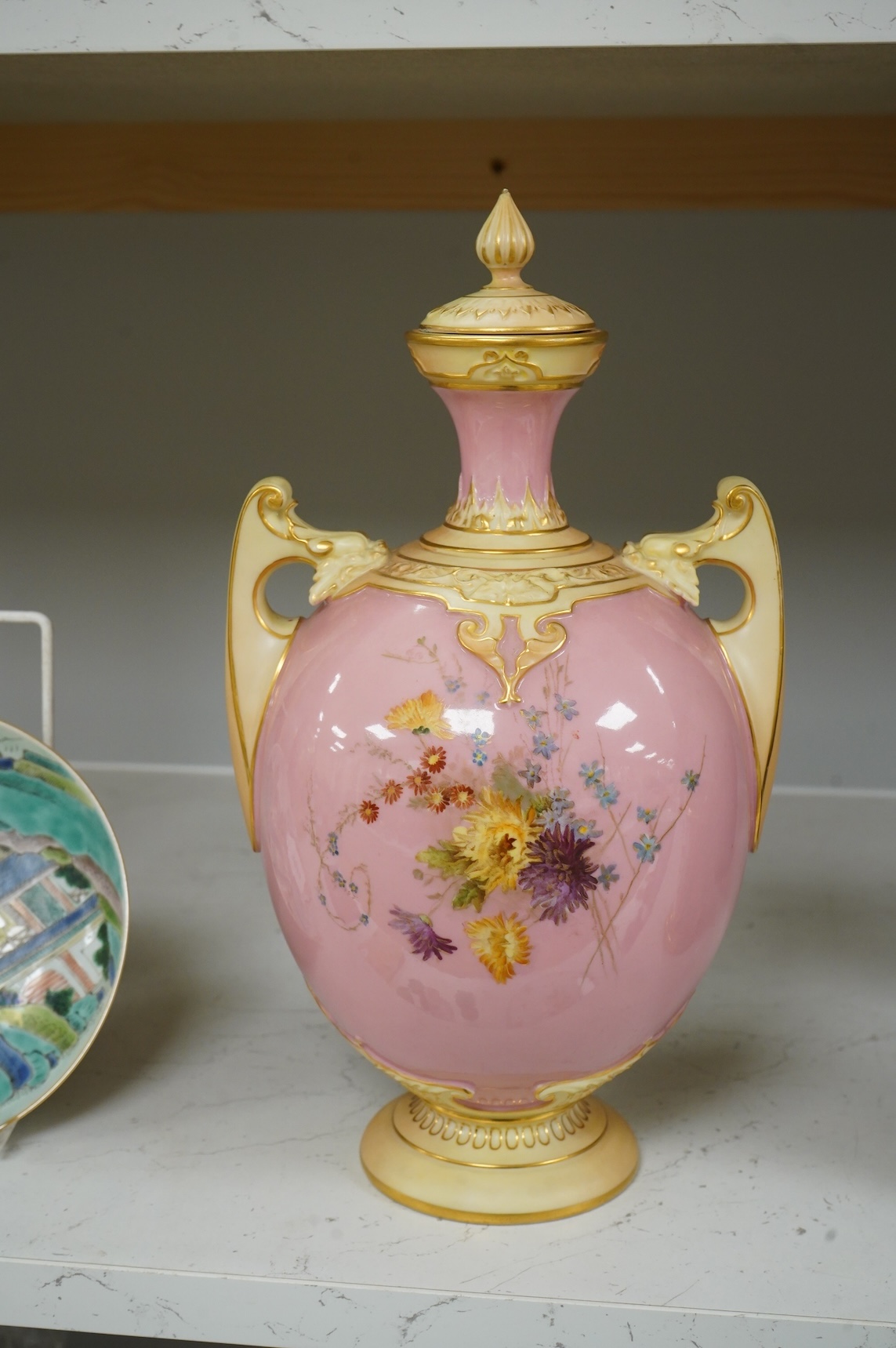 A Royal Worcester floral decorated two handled vase and cover, 30cm